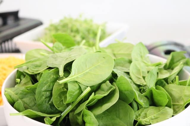Raw spinach on a white bowl.