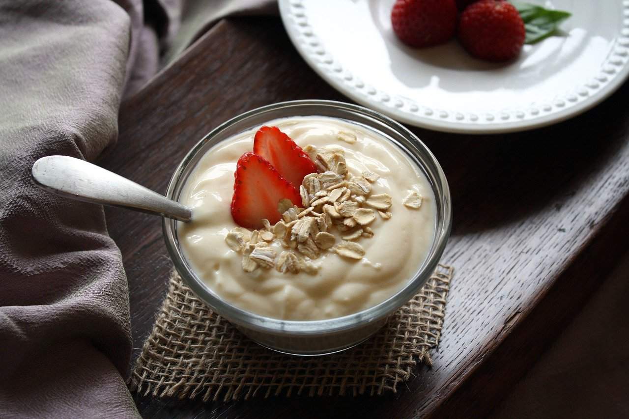 A yogurt in a bowl with fruits. Can rabbits eat yogurt