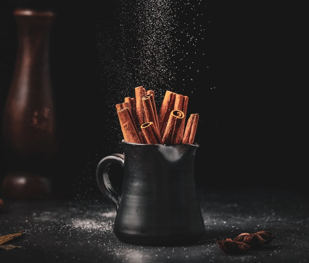 black ceramic jar on black surface full of cinnamon